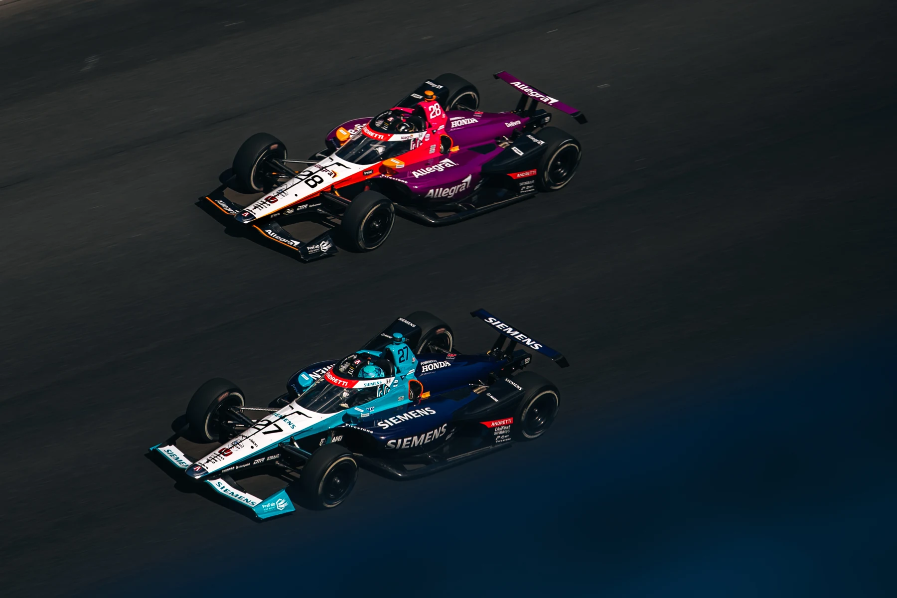 Two IndyCars racing together on track